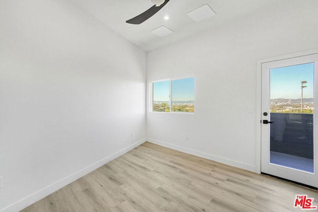 empty room featuring ceiling fan, lofted ceiling, and light hardwood / wood-style flooring