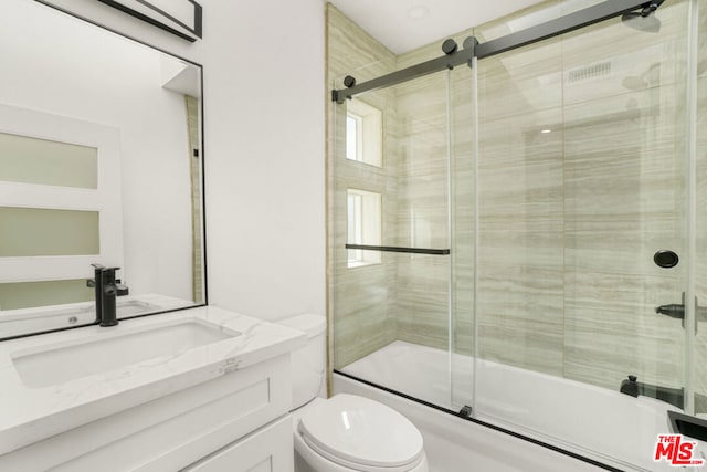 full bathroom featuring vanity, toilet, and enclosed tub / shower combo