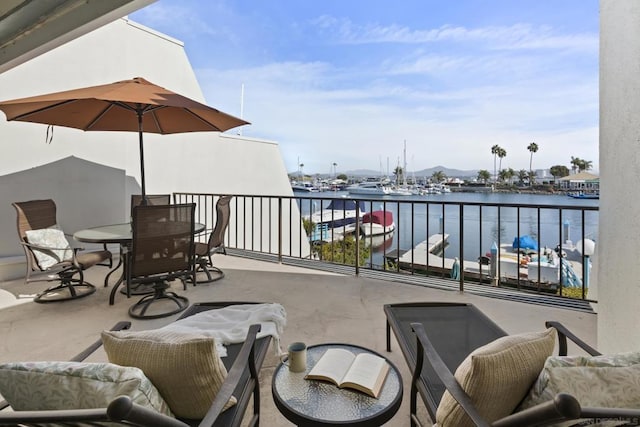 view of patio featuring a water view and a balcony