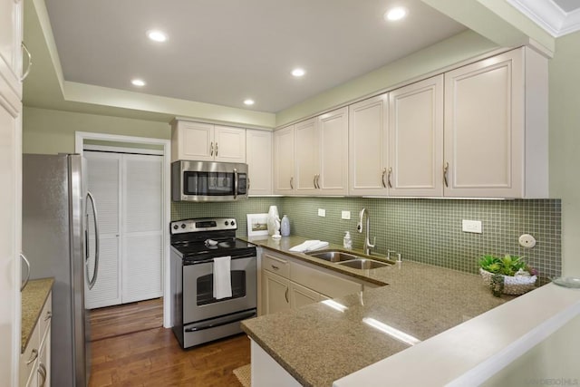 kitchen with sink, dark hardwood / wood-style flooring, decorative backsplash, white cabinets, and appliances with stainless steel finishes