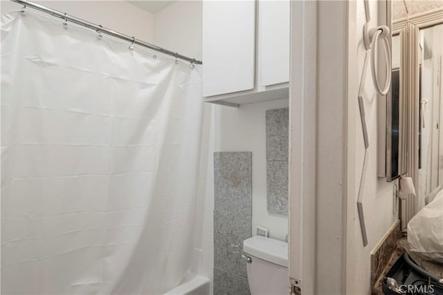 bathroom with toilet and shower / bath combo with shower curtain