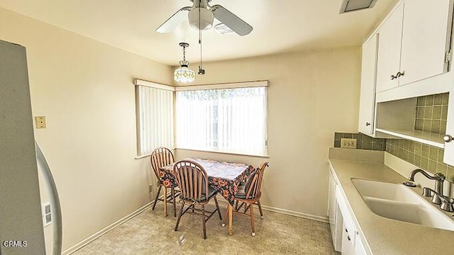 dining space featuring ceiling fan and sink