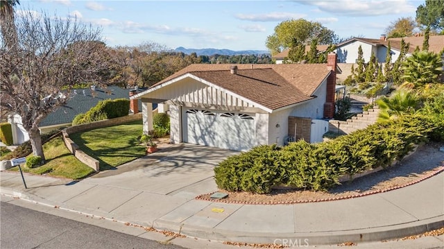 view of front facade with a mountain view, a garage, and a front yard