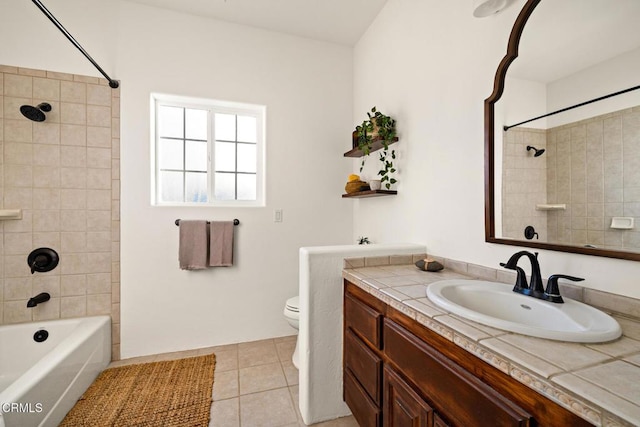 full bathroom featuring tiled shower / bath combo, vanity, tile patterned floors, and toilet