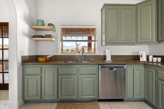 kitchen featuring dishwasher, dark stone countertops, sink, and light tile patterned floors