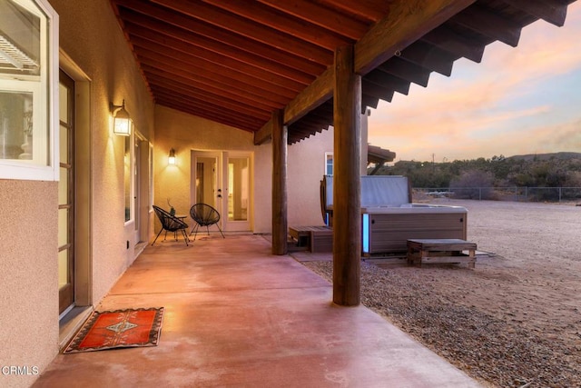 patio terrace at dusk with french doors and a hot tub