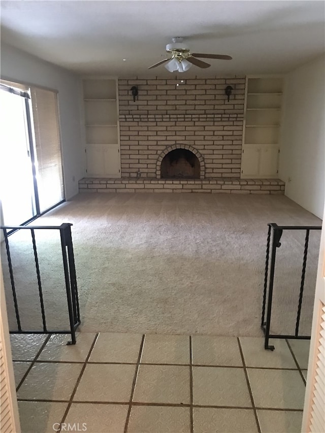 unfurnished living room with built in features, tile patterned floors, and ceiling fan