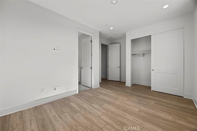 unfurnished bedroom featuring a closet and light hardwood / wood-style flooring