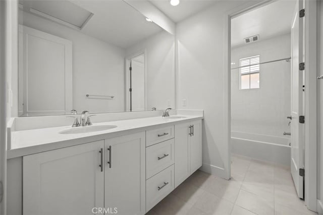 bathroom featuring tile patterned flooring, vanity, and tiled shower / bath combo