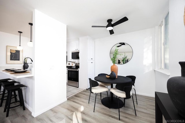 dining room featuring sink, light hardwood / wood-style flooring, and ceiling fan