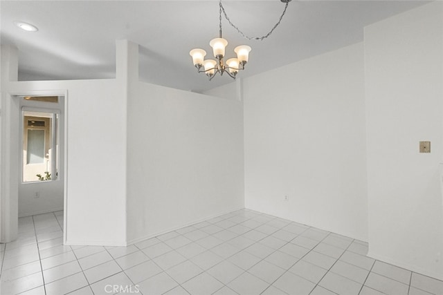 spare room featuring vaulted ceiling, an inviting chandelier, and light tile patterned flooring