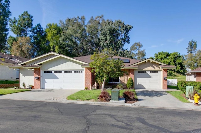 ranch-style house with a garage and solar panels