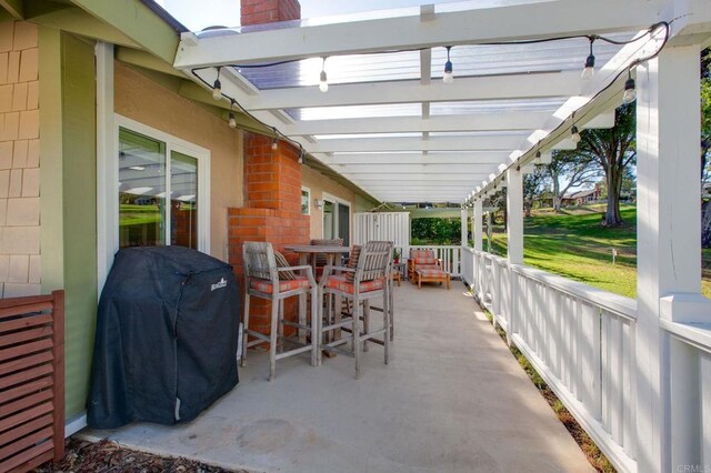 view of patio with grilling area and a pergola