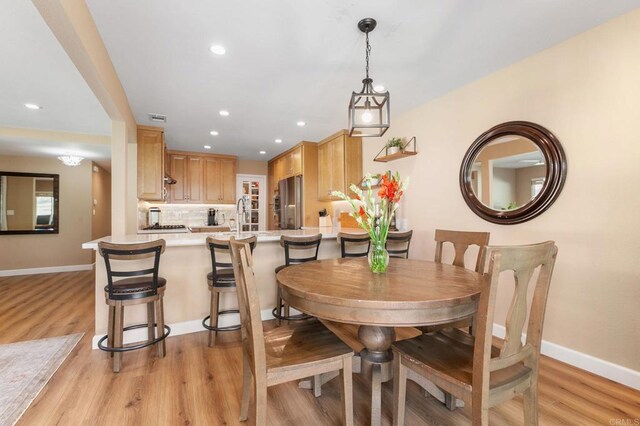 dining space with sink and light hardwood / wood-style floors