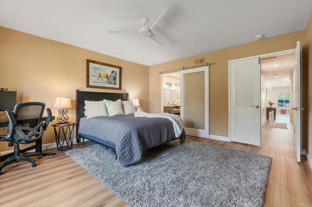 bedroom featuring ceiling fan, wood-type flooring, and ensuite bathroom