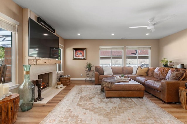 living room with light hardwood / wood-style flooring and ceiling fan