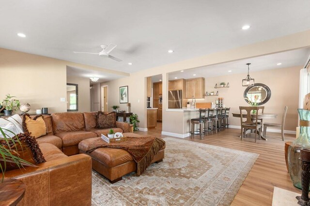 living room featuring ceiling fan and light wood-type flooring