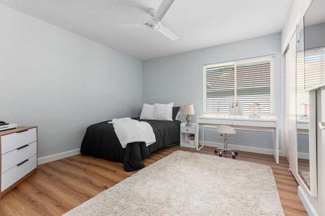 bedroom with ceiling fan, multiple windows, and light hardwood / wood-style flooring