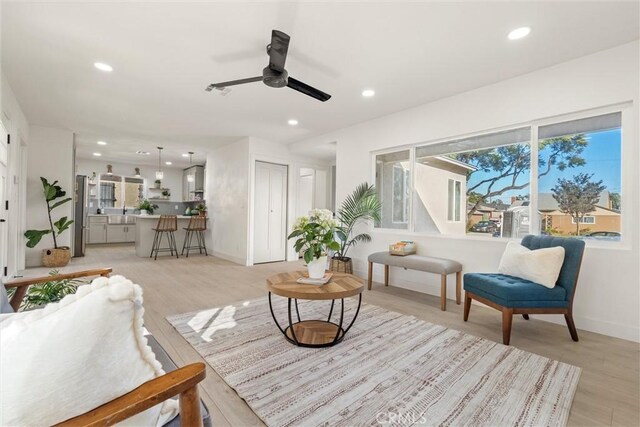 sitting room featuring ceiling fan and light hardwood / wood-style floors