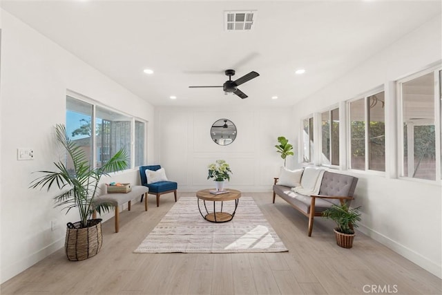 sitting room with ceiling fan, light wood-type flooring, and a wealth of natural light