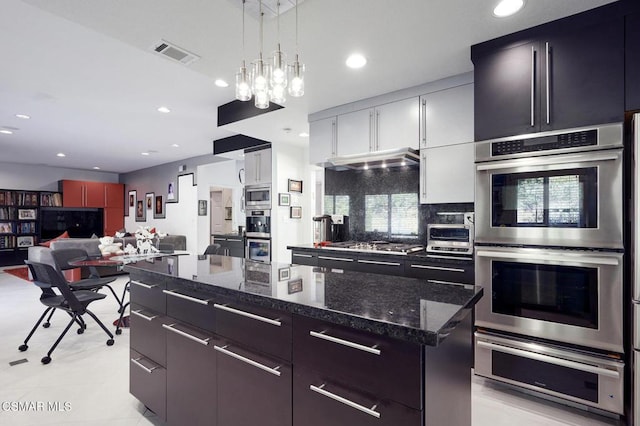 kitchen with a center island, hanging light fixtures, decorative backsplash, white cabinetry, and stainless steel appliances