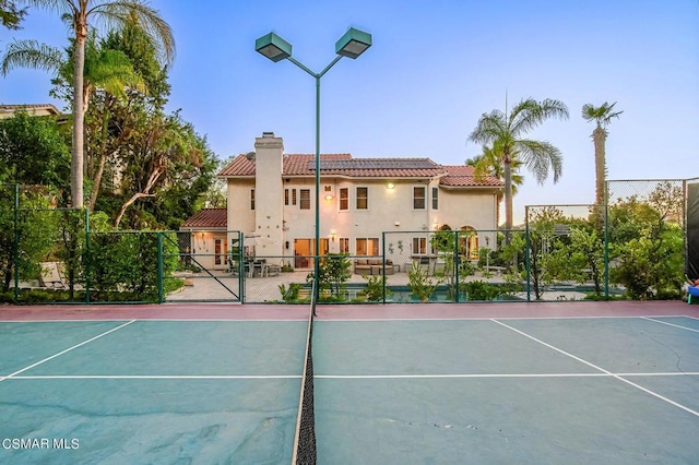 view of tennis court featuring basketball hoop