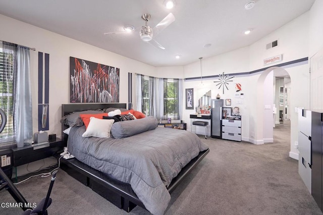 carpeted bedroom with multiple windows and ceiling fan