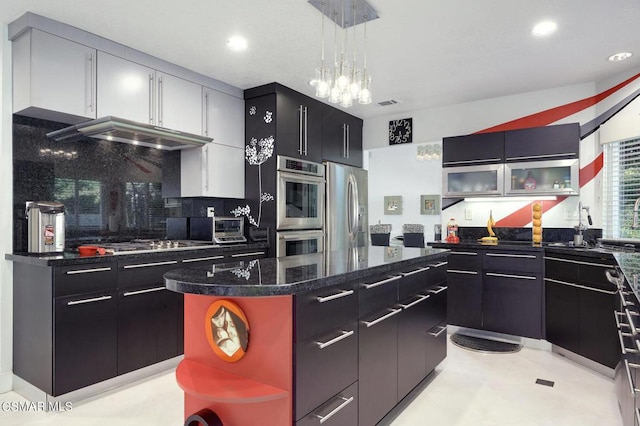 kitchen featuring pendant lighting, a center island, tasteful backsplash, a notable chandelier, and stainless steel appliances