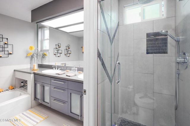 bathroom with tile patterned flooring, plenty of natural light, independent shower and bath, and vanity