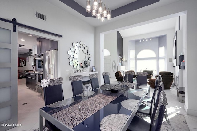 dining room with a barn door, light tile patterned floors, and a notable chandelier