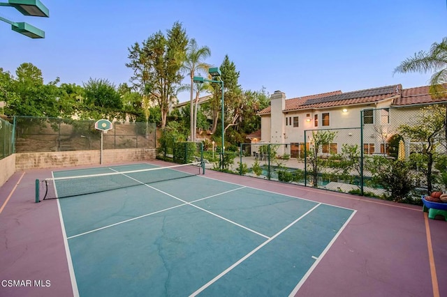 view of tennis court featuring basketball hoop