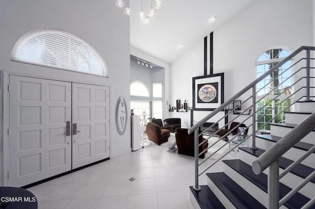 tiled foyer featuring high vaulted ceiling and a wealth of natural light