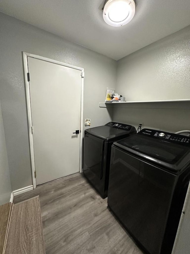 clothes washing area featuring light wood-type flooring and independent washer and dryer