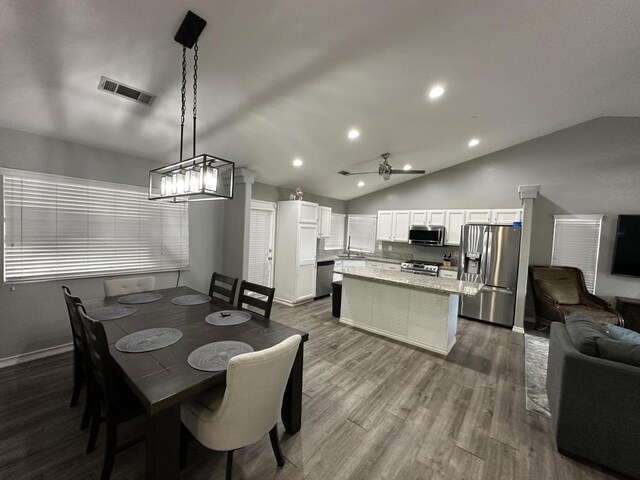 dining area featuring vaulted ceiling, ceiling fan, hardwood / wood-style floors, and sink