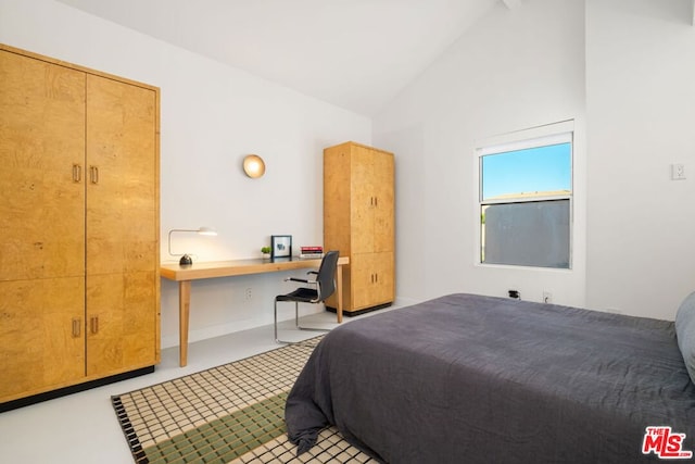 bedroom with a closet, built in desk, and vaulted ceiling