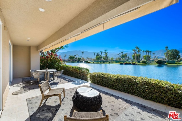 view of patio / terrace featuring a water and mountain view