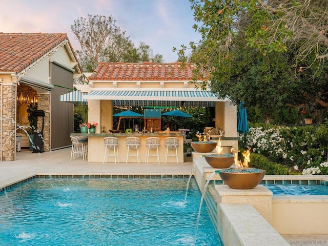 view of pool with pool water feature and an outdoor bar