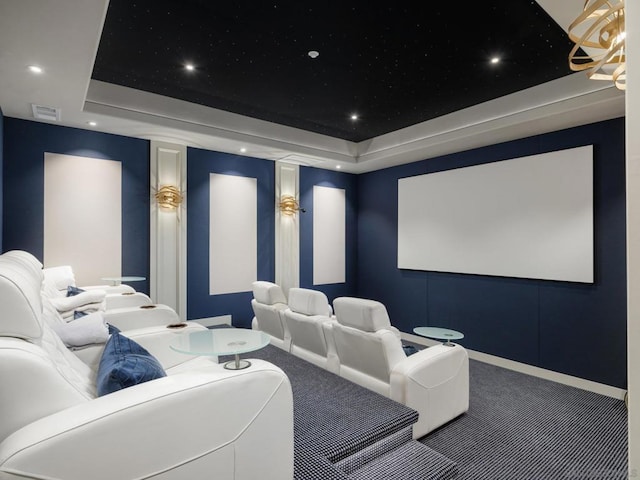 home theater room with a raised ceiling and carpet