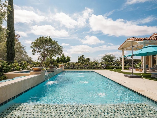 view of swimming pool with pool water feature, an in ground hot tub, and a patio