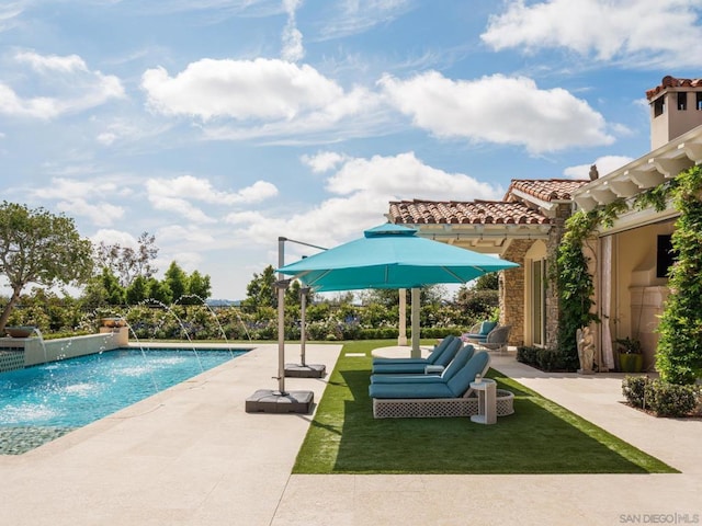 view of swimming pool featuring pool water feature, a patio area, and a yard