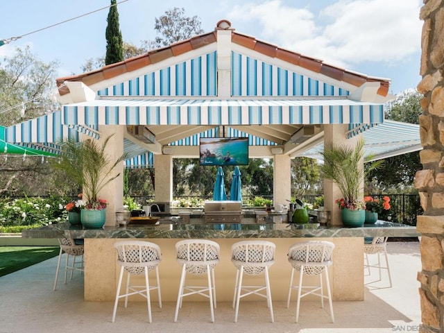 view of patio / terrace featuring a gazebo, exterior kitchen, exterior bar, and grilling area