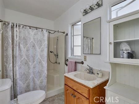 bathroom featuring toilet, vanity, and curtained shower