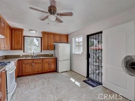 kitchen featuring ceiling fan, plenty of natural light, sink, and white appliances