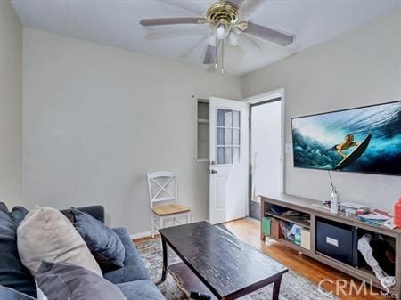 living room featuring ceiling fan and hardwood / wood-style floors