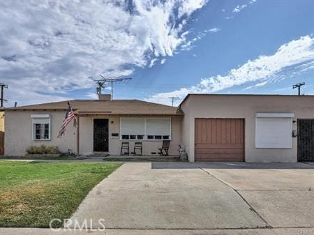 ranch-style home featuring a front lawn and a garage