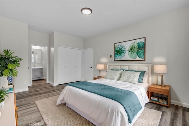 bedroom with dark hardwood / wood-style flooring and ensuite bath