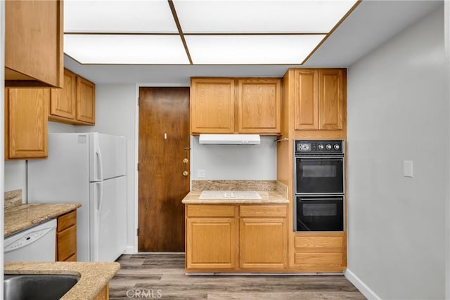 kitchen with white appliances and hardwood / wood-style flooring