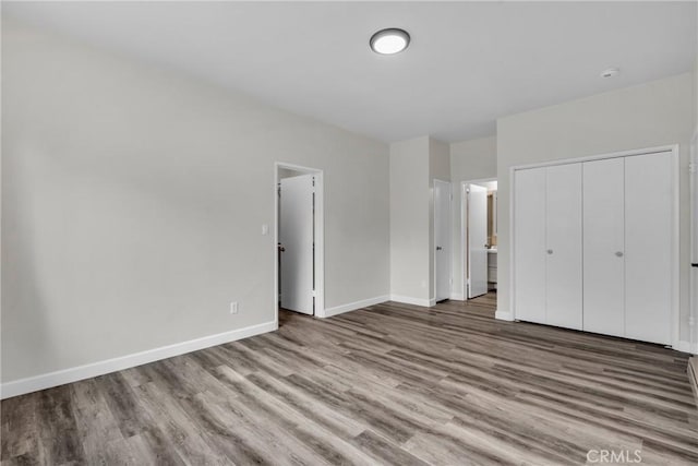 unfurnished bedroom with light hardwood / wood-style floors and a closet