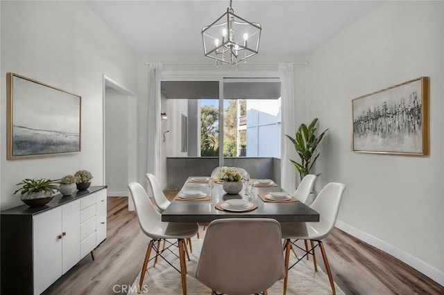 dining area featuring an inviting chandelier and light hardwood / wood-style flooring