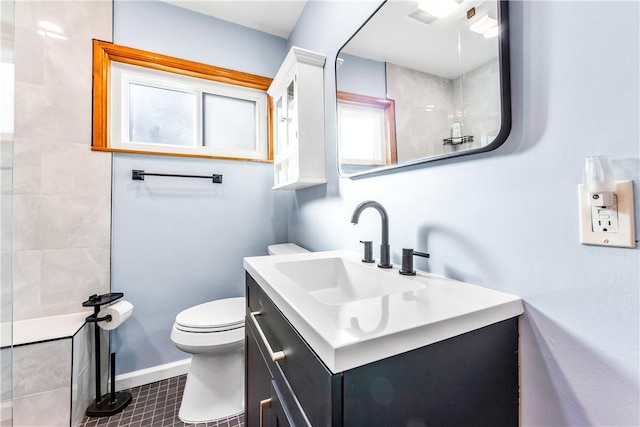 bathroom with vanity, toilet, and tiled shower